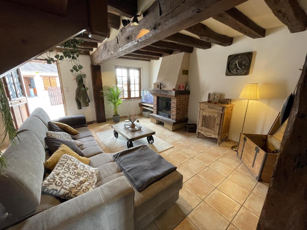 sala de estar con sofá y chimenea en Les sables d’or avec billard: Château & Beauval, en Lanthenay