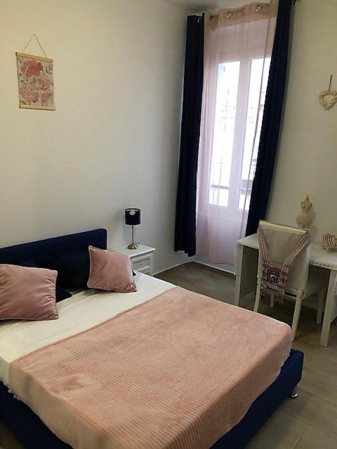 a bedroom with a bed and a table and a window at Charmant F4 proche de la gare Saint Charles in Marseille
