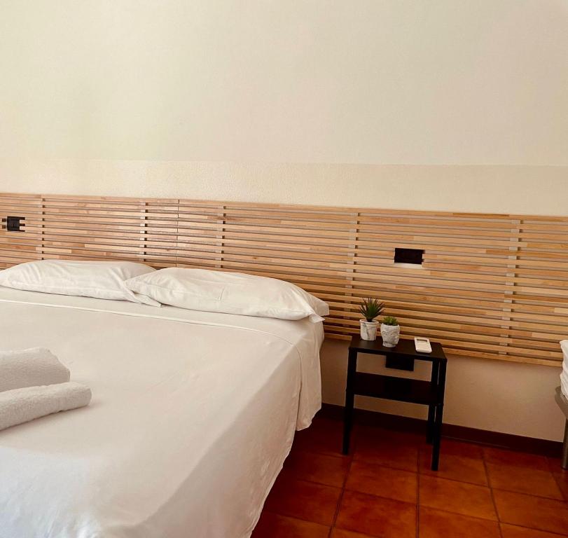 a bedroom with two white beds and a night stand at A Paranza in Curtatone