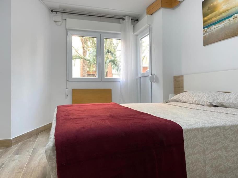 1 dormitorio con 1 cama grande con manta roja en Puerto Playa Oceanografico Yulia, en Valencia