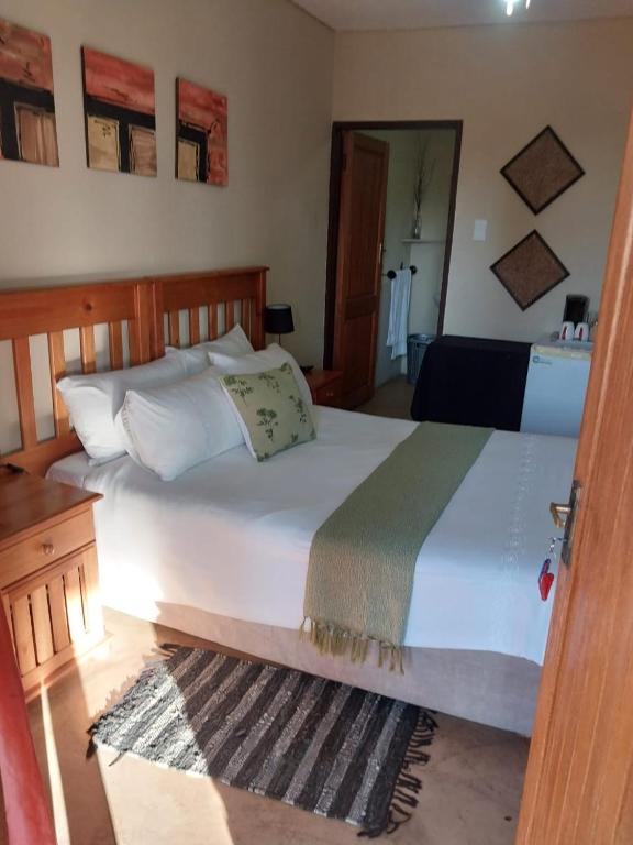 a bedroom with a large white bed in a room at Kwena Maribane Lodge in Bronkhorstspruit