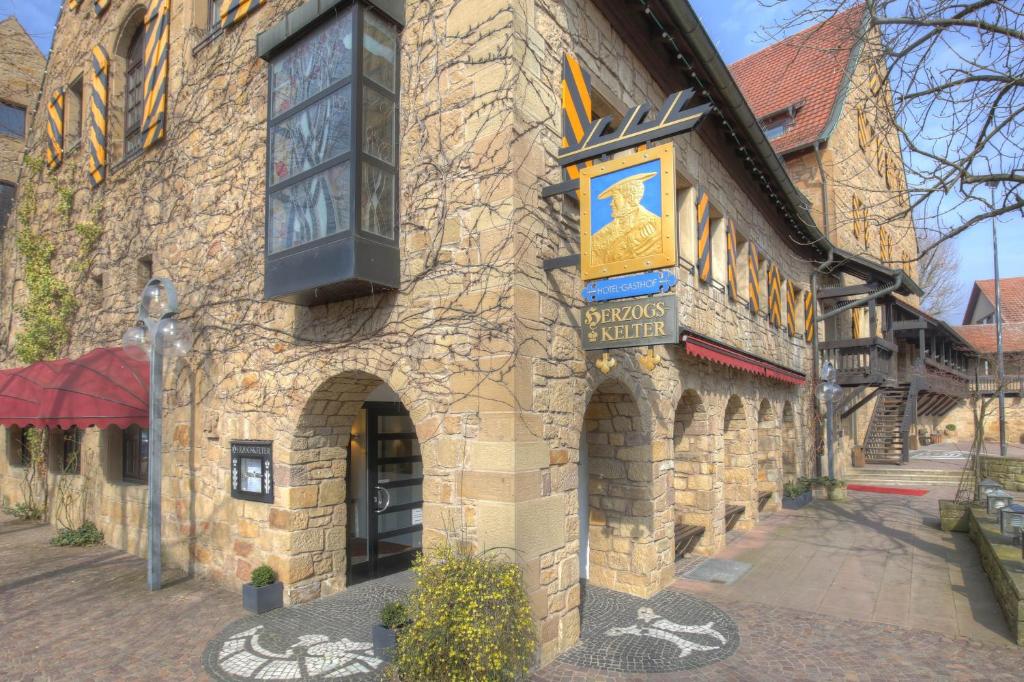 um edifício de pedra com um sinal na lateral em Herzogskelter Restaurant Hotel em Güglingen