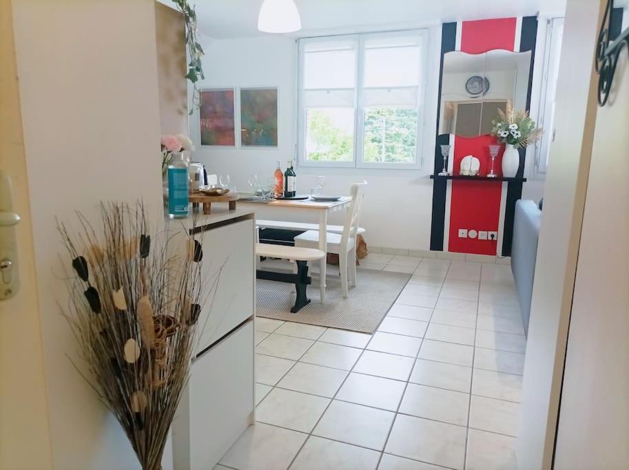 a kitchen with a table and a dining room at Le Duplex Décontracté in Fleury-les-Aubrais