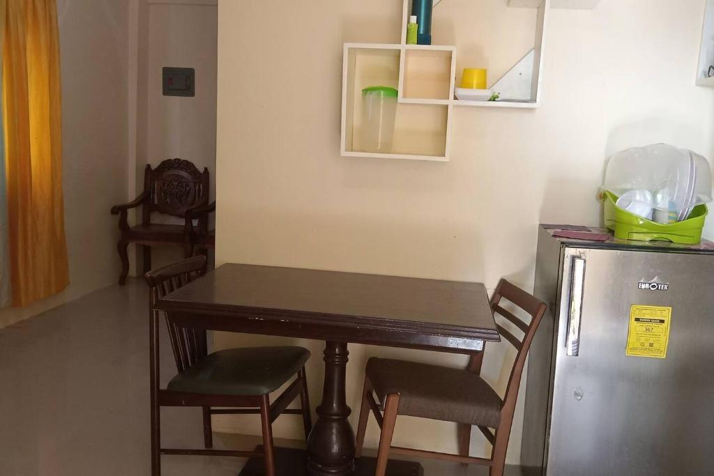 a kitchen with a table and chairs and a refrigerator at A Parallag apartment in Manila