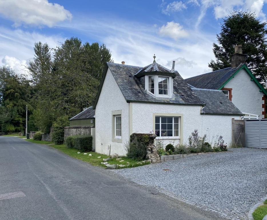 a white house on the side of a road at Rossearn Cottage in Comrie