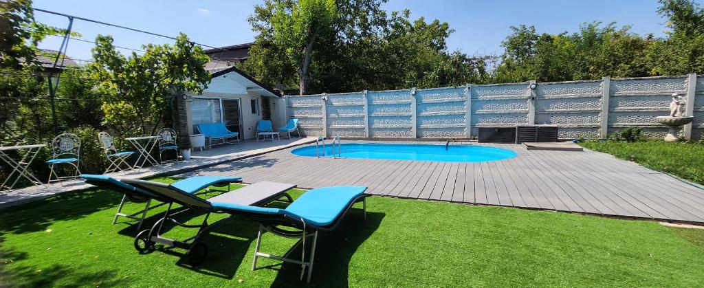 une arrière-cour avec une terrasse et une piscine avec des chaises dans l'établissement Morii Lake Pool Villa, à Bucarest