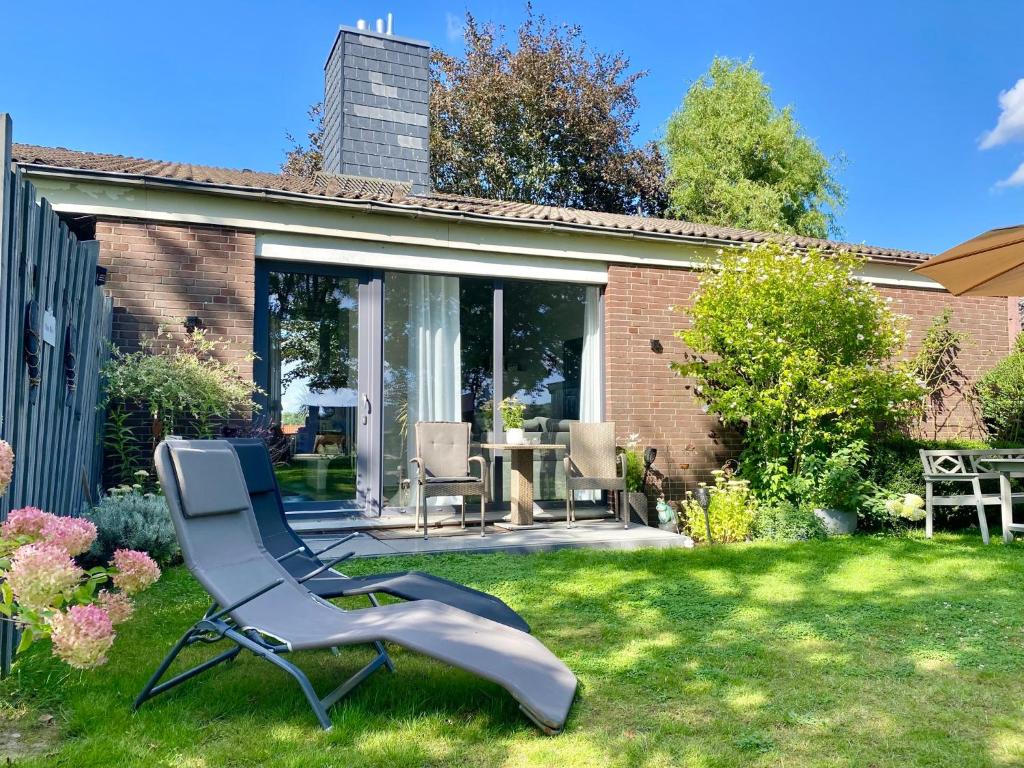 a chair sitting in the grass in a yard at Ferienwohnung Nina in Egestorf