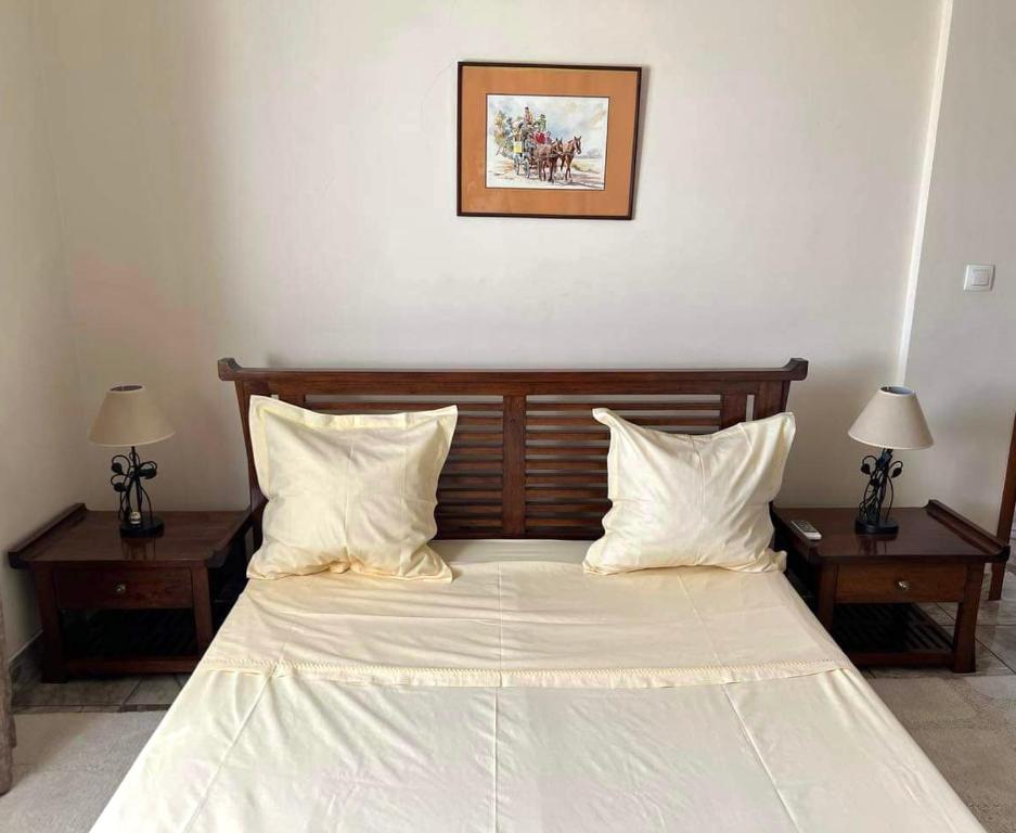 a bedroom with a bed with two tables and two lamps at Mahajanga Residences in Mahajanga