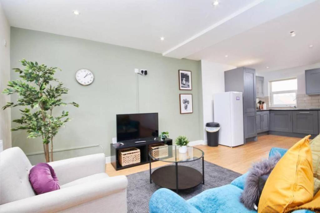 ein Wohnzimmer mit einem weißen Sofa und einem TV in der Unterkunft Spacious Bristol Apartment - Parking & WIFI in Bristol