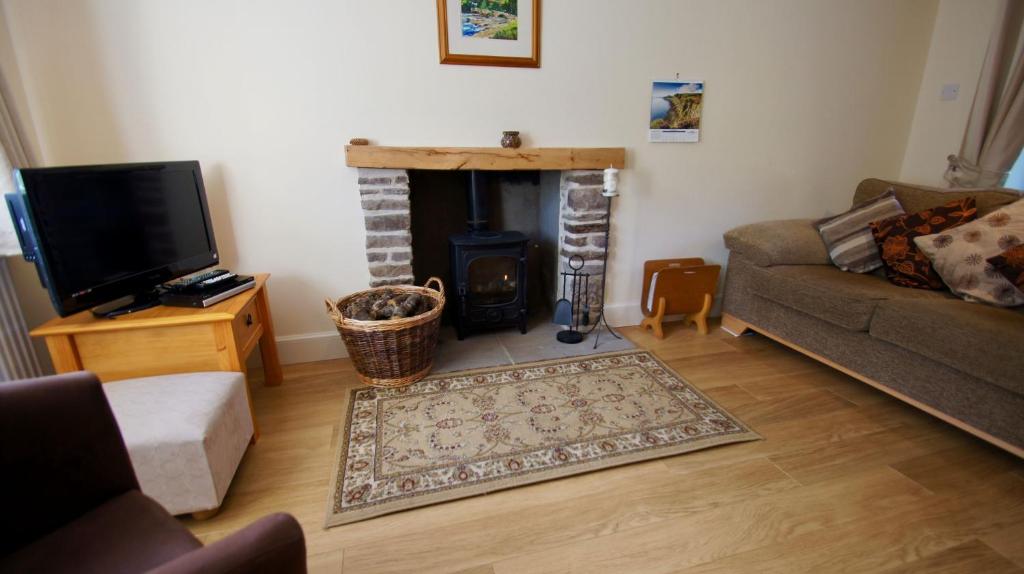 a living room with a fireplace and a couch at Waterside in Braco