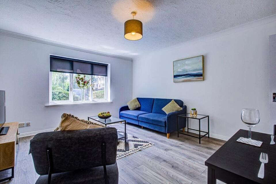 a living room with a blue couch and a table at Spacious 2 Bedroom Apartment in London