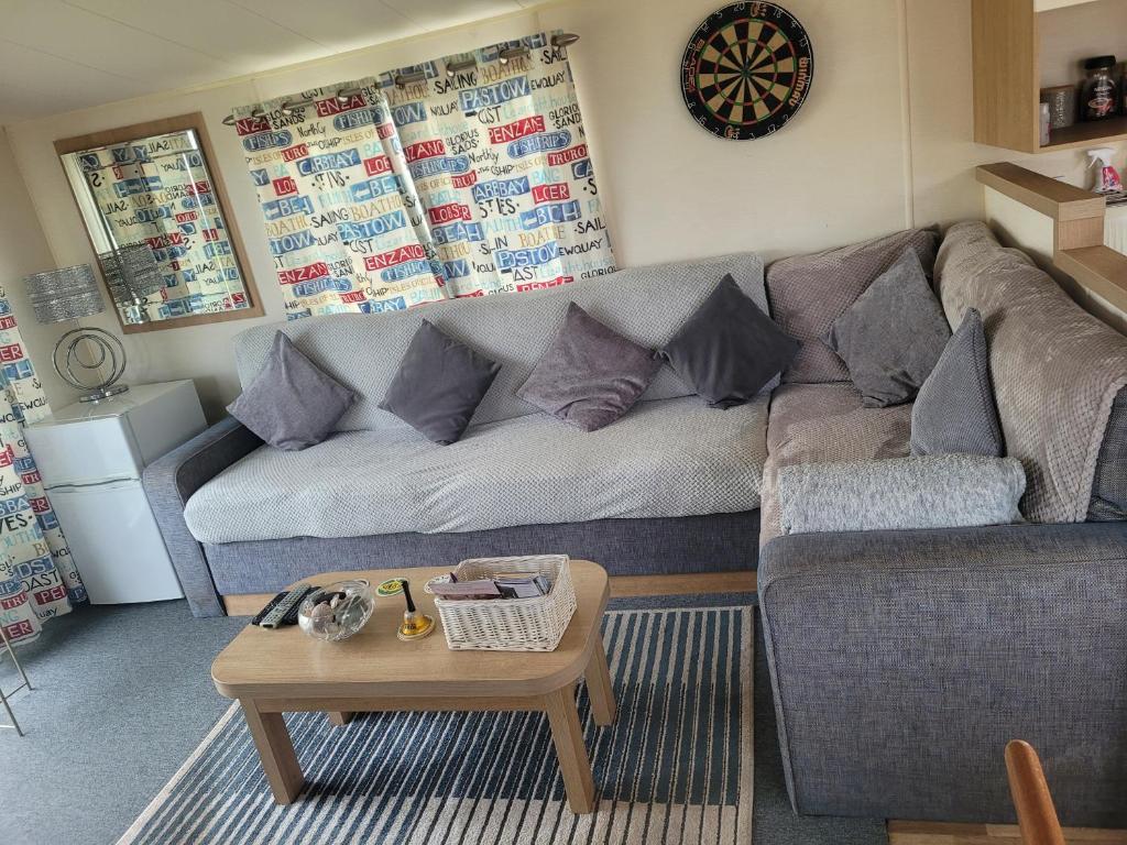 a living room with a couch and a coffee table at Arual Caravan Manor House Park. Allonby, Cumbria in Maryport