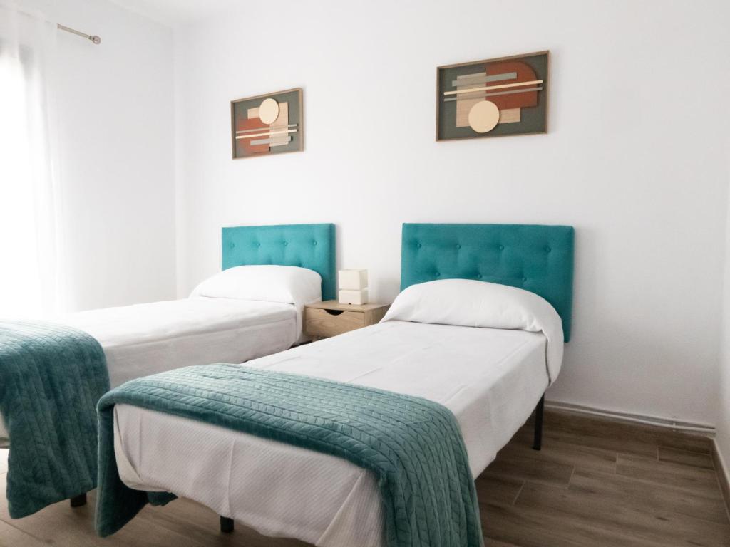 duas camas num quarto com verde e branco em VUT Adarve em Ávila