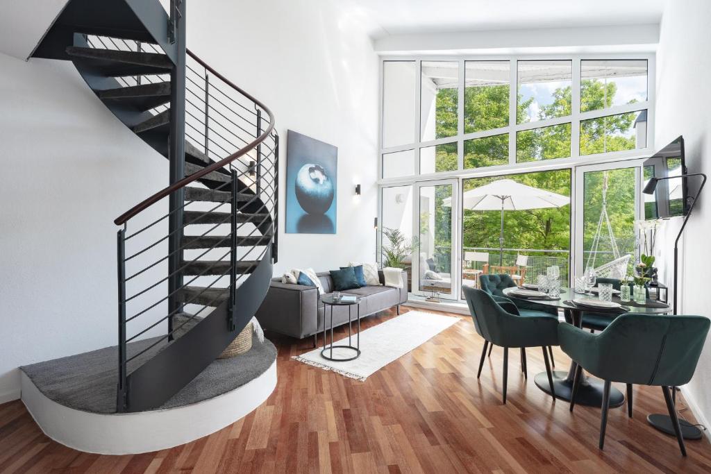 a living room with a spiral staircase and a dining room at Blueberry Living - Design Loft nahe München - Dachterrasse - S-Bahn in Gauting
