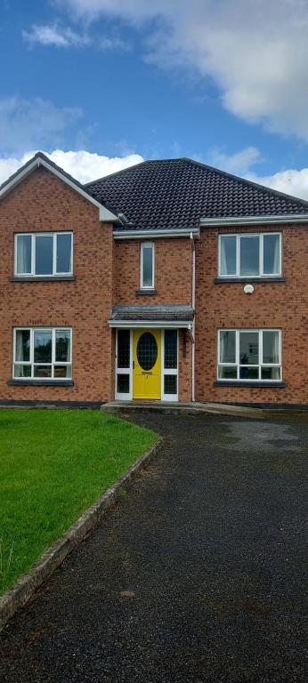 una casa de ladrillo con puerta amarilla en 1 Cartrun Breac N39D7H6 Opposite Longford Rugby Club - See the Yellow Door, en Longford