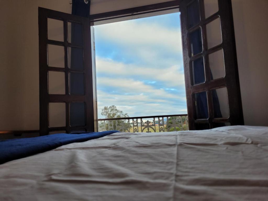 a bedroom with a bed and a window with a view at Hostel BoituVillage in Boituva