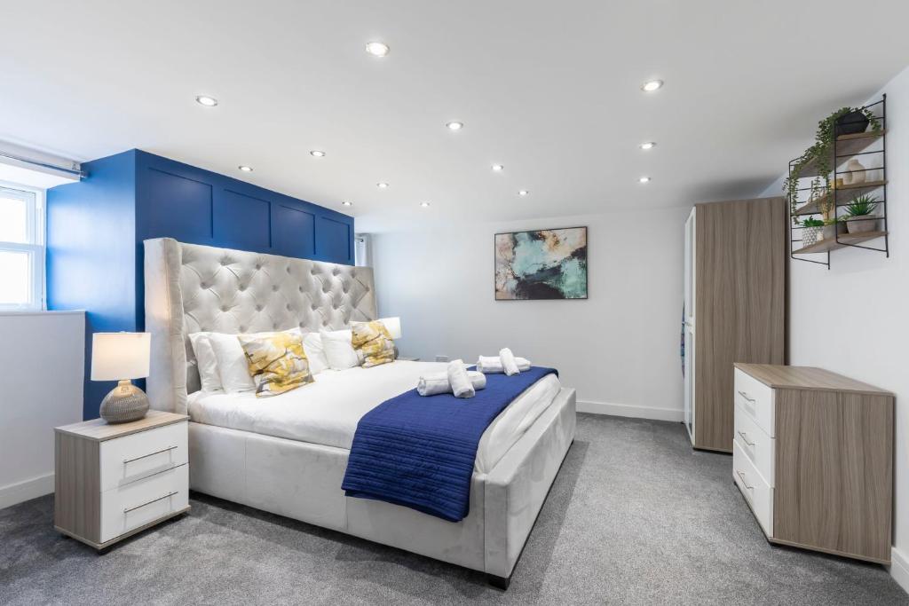 um quarto com uma cama grande e uma cabeceira azul em Prestbury Road em Cheltenham