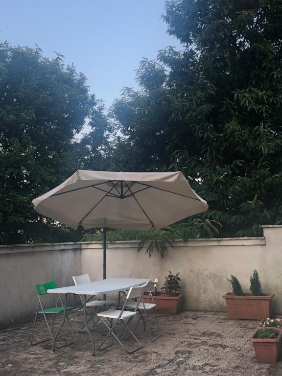 een tafel en twee stoelen en een paraplu bij La frescura in Roccamonfina