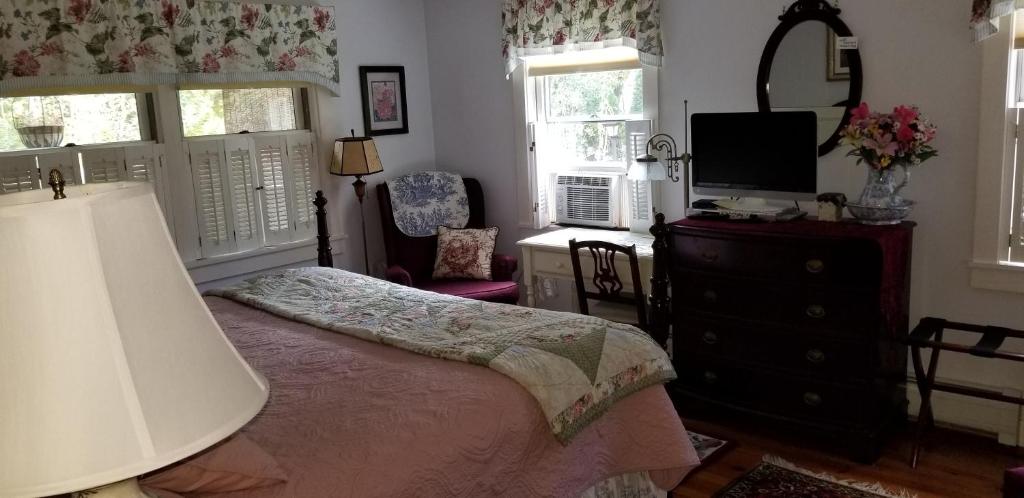 a bedroom with a bed and a dresser with a mirror at Eastgate Inn B&B in Lenox