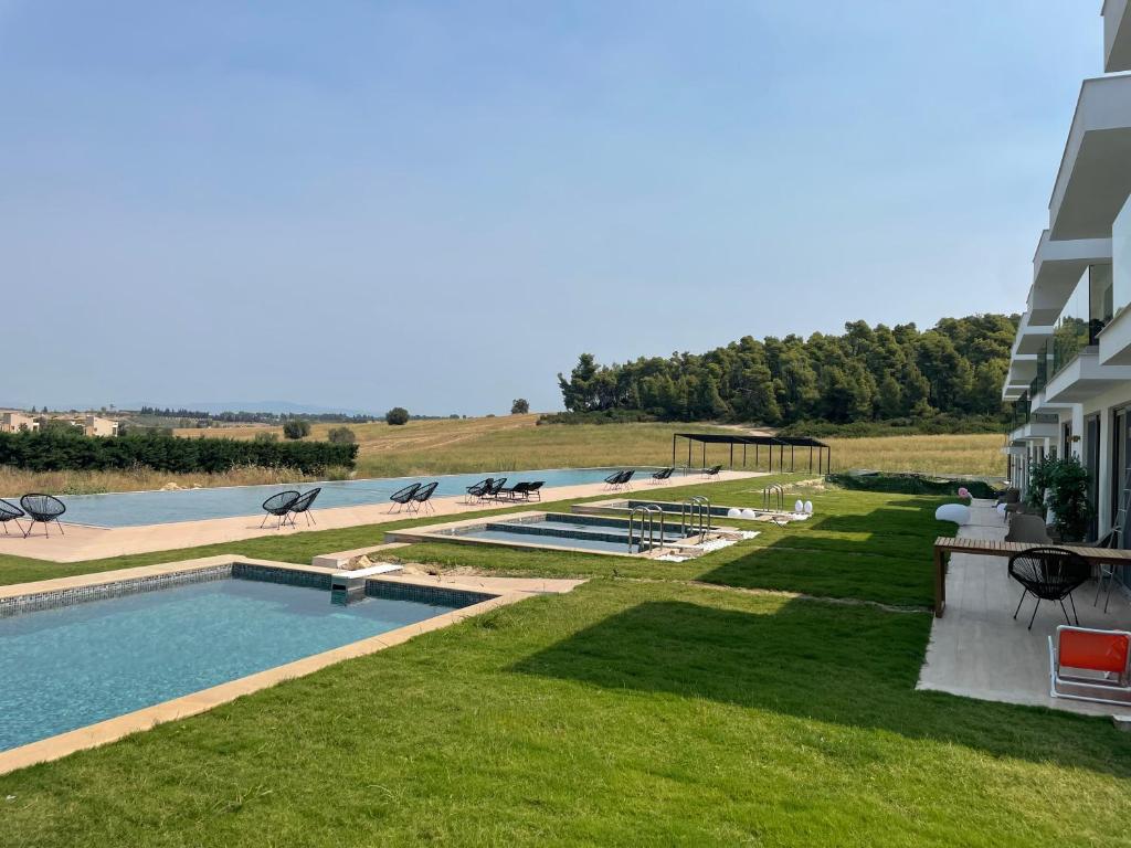 a resort with a swimming pool and a building at Oikos Sani Suites in Sani Beach