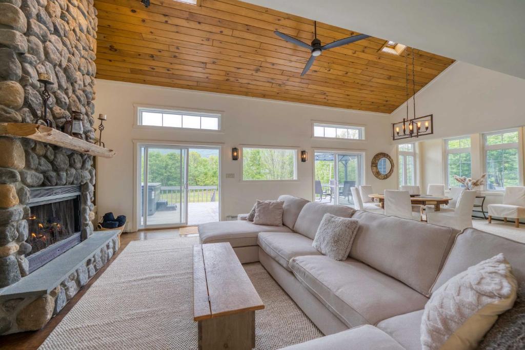Una sala de estar con un sofá y una chimenea. en The Mountain House Windham Retreat with Hot Tub!, en Windham