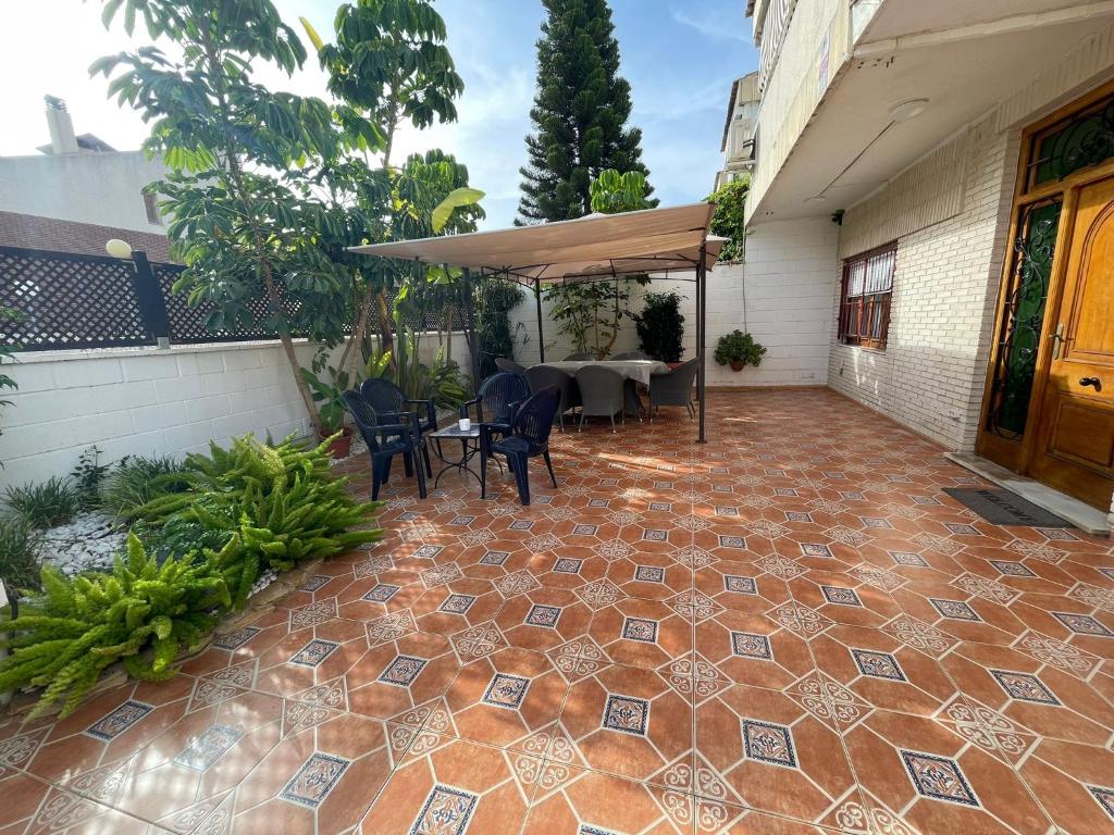 d'une terrasse avec une table et des chaises sur un sol en briques. dans l'établissement Bungalow familiar con piscina, à San Juan de Alicante