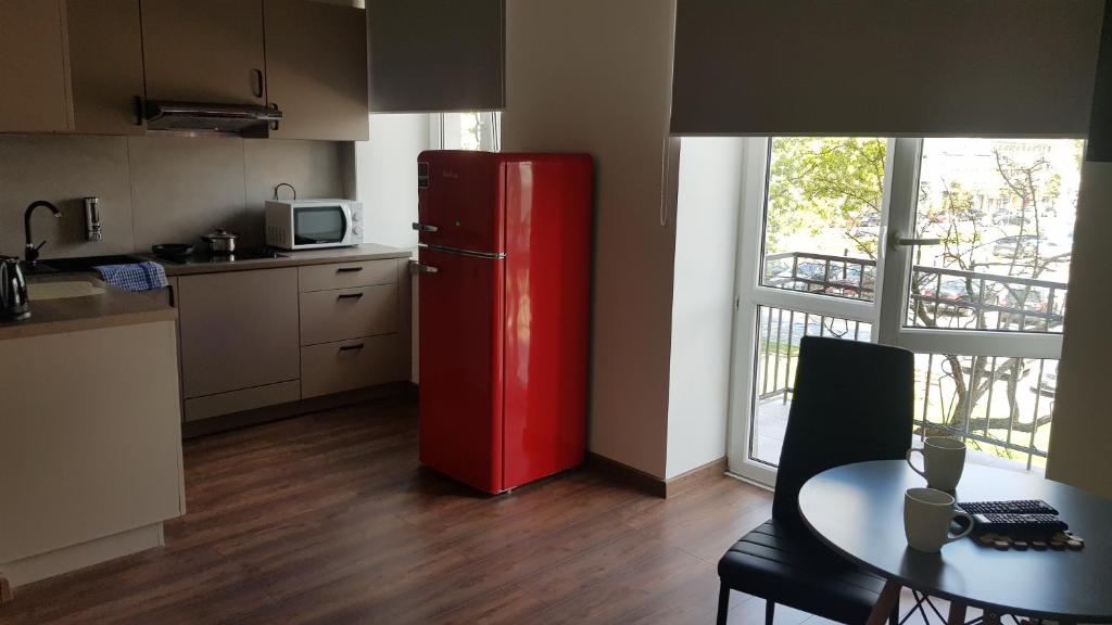 una nevera roja en una cocina con mesa en Apartamenty Centrum Plac Wolności ApartHotel, en Kielce