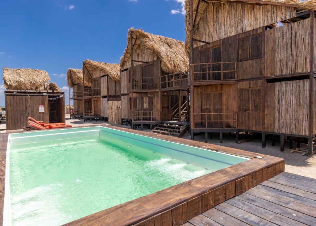 un resort con piscina e capanne con tetto in paglia di CasaSolea a Mayapo