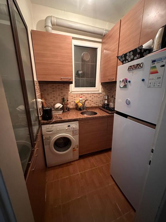 a kitchen with a white refrigerator and a washing machine at Bomontide metroya çok yakın şirin daire in Istanbul