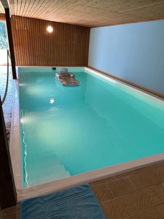 una piscina con agua azul en una habitación en Home of Oasis, en Surwold