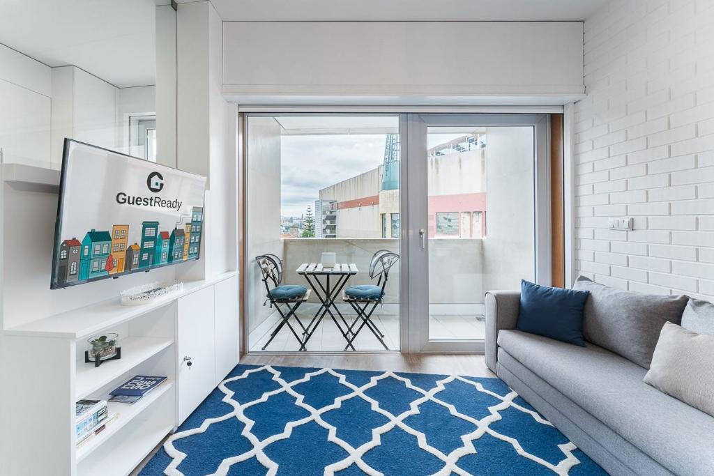 a living room with a couch and a table at GuestReady - Bright Studio with balcony in Vila Nova de Gaia