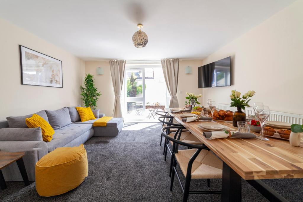a living room with a table and a couch at Arte Stays- 3-Bedrooms 2-Bathrooms Garden Spacious House London, Stratford, Free Parking, 6 min walk Elizabeth Line, Weekly or Monthly stays, Serviced accommodation - 7 guests in London