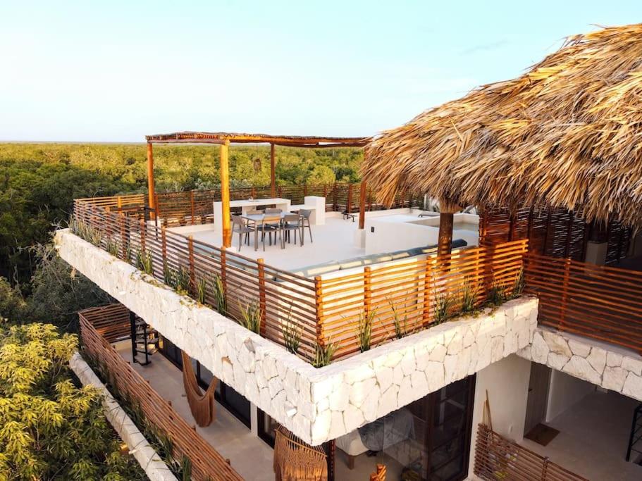 an aerial view of a building with a thatch roof at Private Rooftop Penthouse with pool, BBQ & Jungle View in Tulum