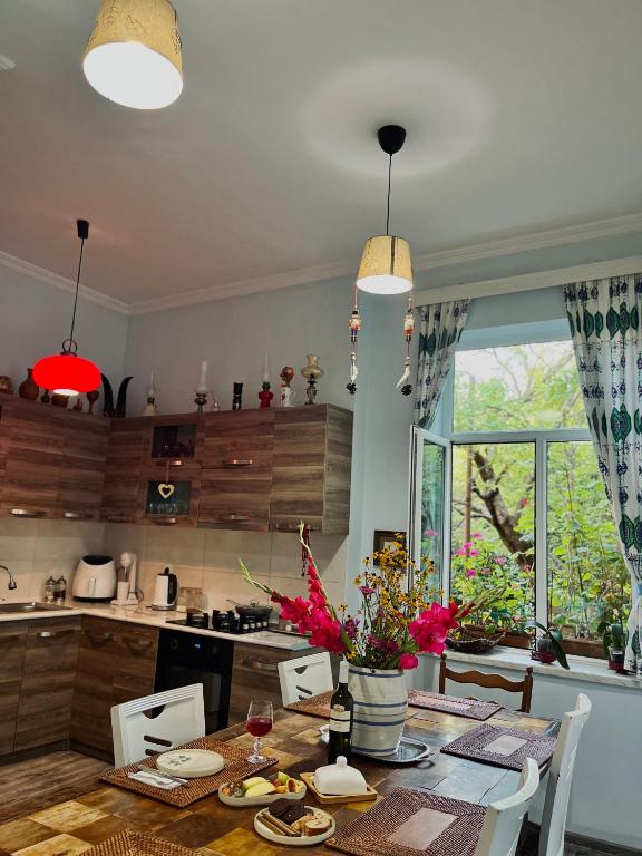a kitchen with a wooden table with chairs and a dining room at Guest House Hello in Kutaisi