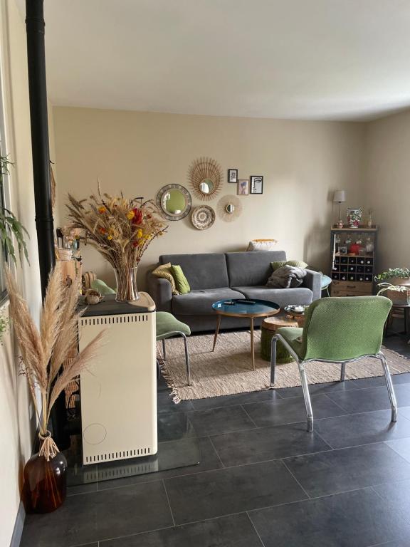 a living room with a blue couch and green chairs at Chambre avec petit dej à 2kms du centre de Nevers in Varennes Vauzelles