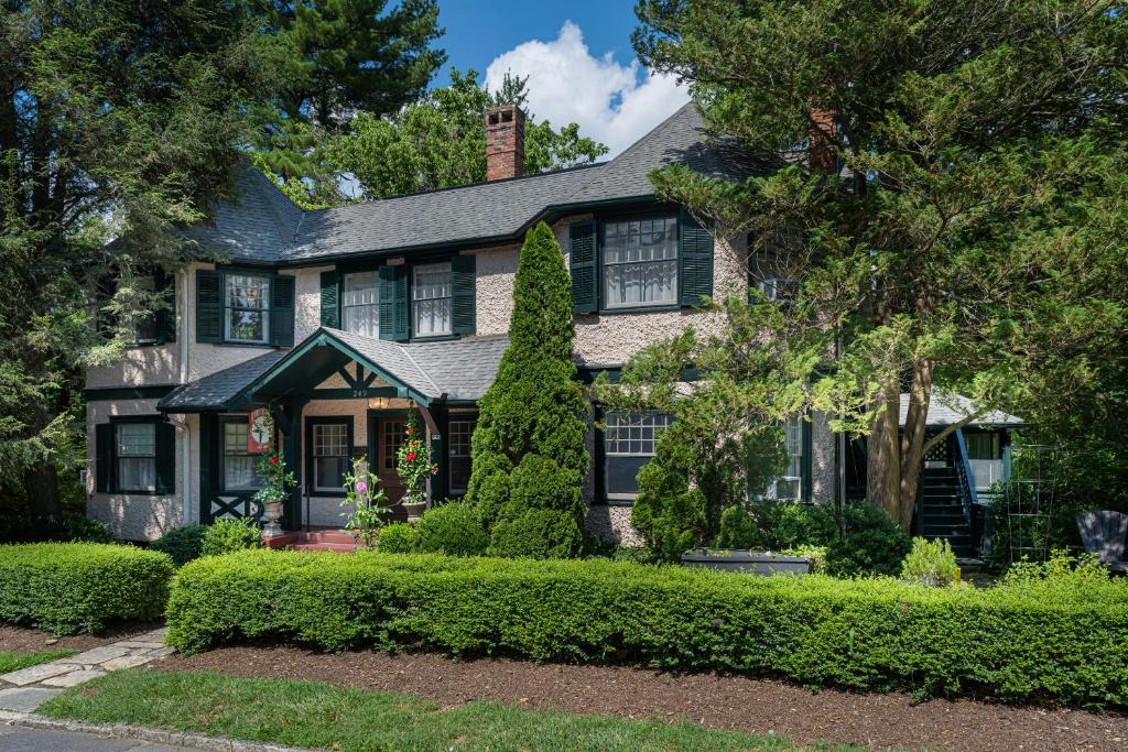 uma casa com sebes verdes em frente em Pinecrest Bed & Breakfast em Asheville