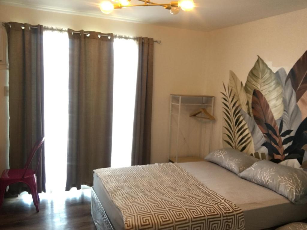 una camera con un letto in una stanza con finestre di La Reina Suite Tuscania Towers a Cagayan de Oro