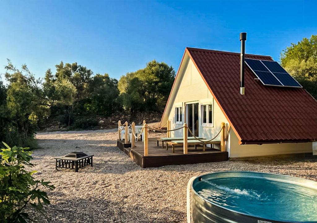 una casa con piscina y una casa con techo solar en Unique Stay - Eco Country A-Frame Cabin, en Cabanes