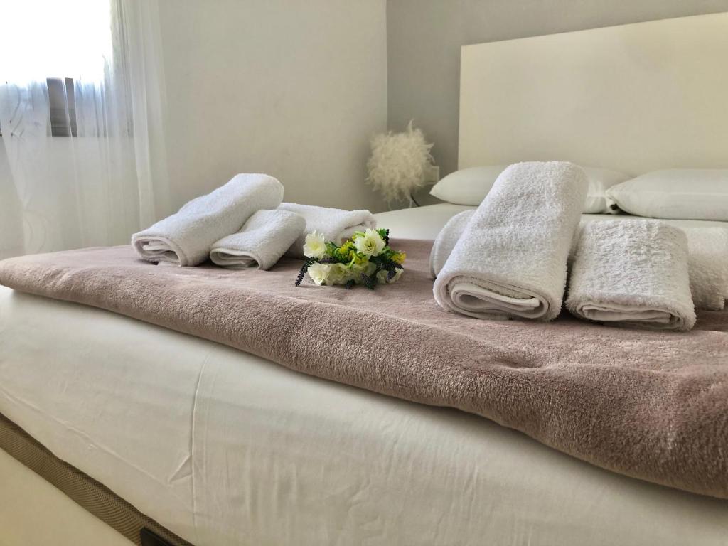 a bed with towels and flowers on top of it at La Casa de Jordi&Lina in Miami Platja