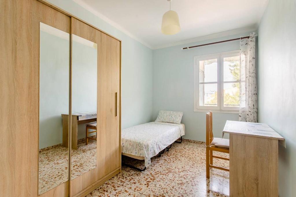 1 dormitorio con cama, escritorio y ventana en Habitacion privada y tranquila, en Alicante