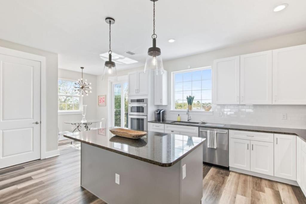a kitchen with white cabinets and a large island at Waters Edge at Cortez in Saint Augustine