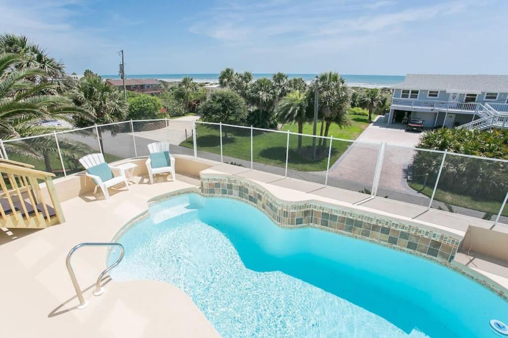 a swimming pool with a view of the ocean at The Sand Castle Heated Pool Atlantic Ocean in St. Augustine