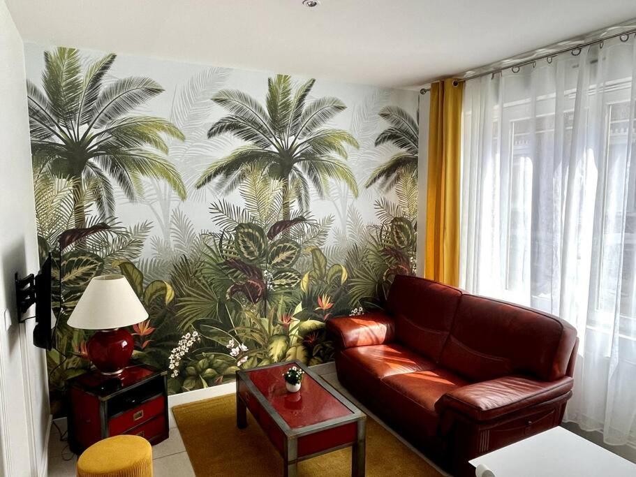 - un salon avec un canapé et des palmiers sur le mur dans l'établissement Appartement avec extérieur, à Loos