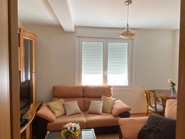 a living room with a couch and a table at Lar dos Galos in Bueu