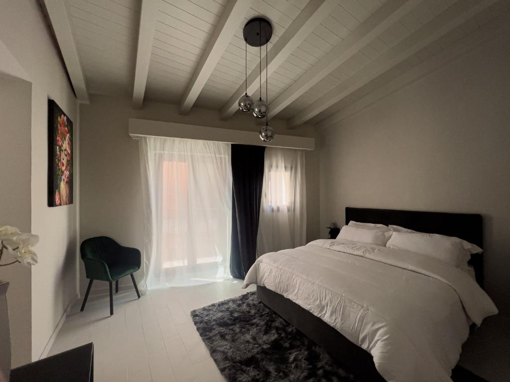 ein Schlafzimmer mit einem Bett, einem Stuhl und einem Fenster in der Unterkunft VICOLO SAN GAETANO -luxury rooms- in Catania