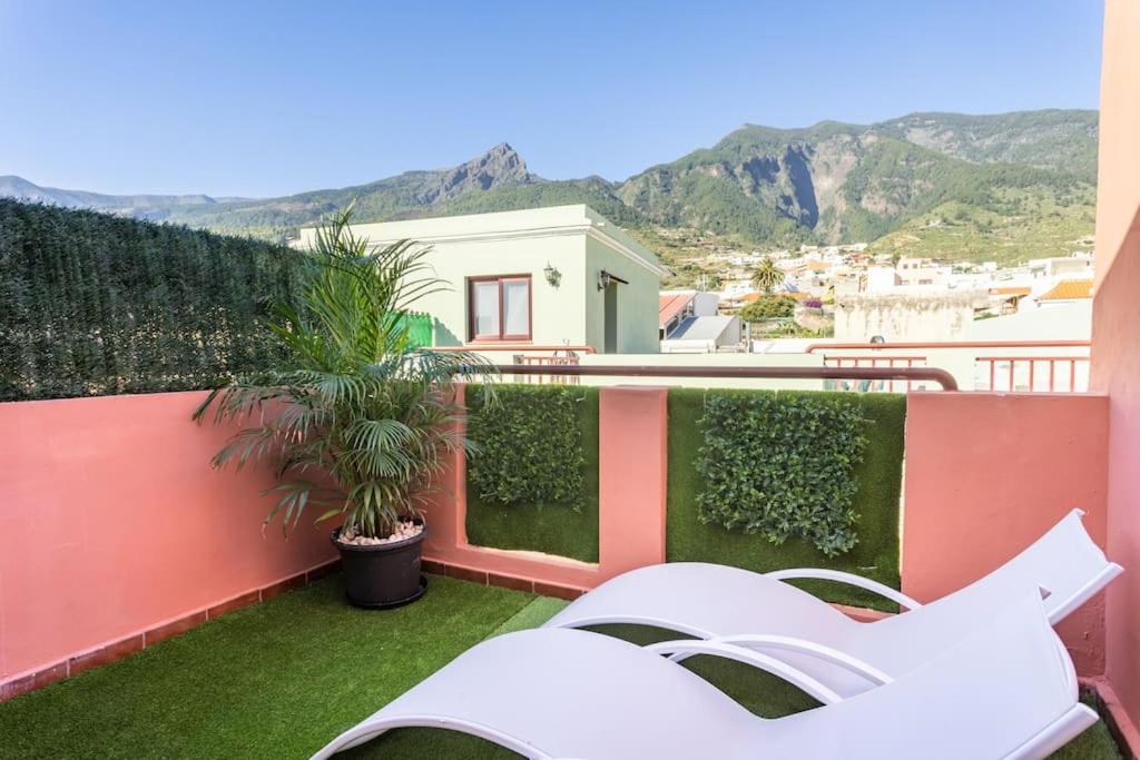 un balcón con sillas y plantas en un edificio en Ático. Vistas al mar y montaña., en Arafo