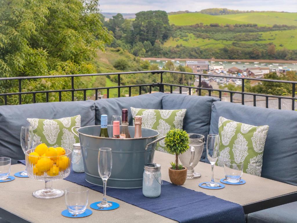 a table with wine glasses and oranges on a balcony at Ash Tree House in Salcombe