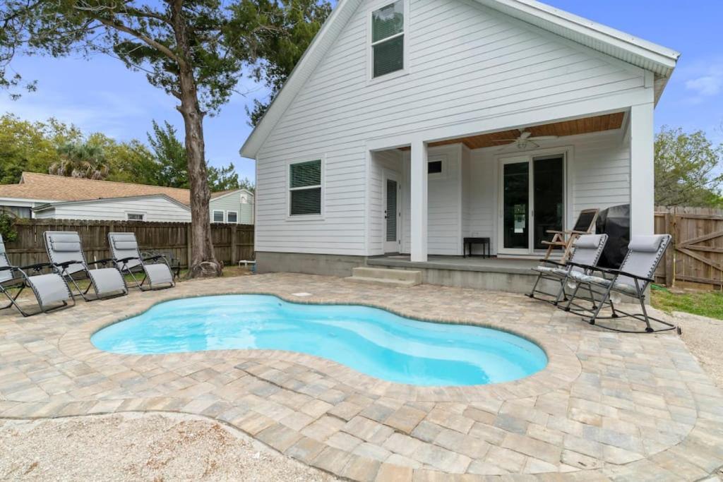 a patio with a pool and chairs in front of a house at Lions Sail Beach Island Pool in Saint Augustine