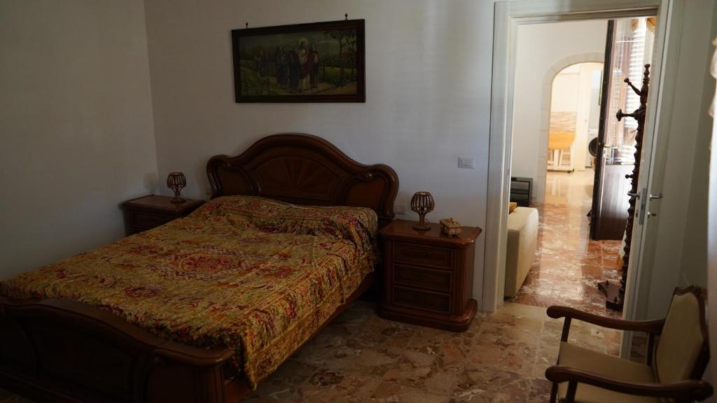 een slaapkamer met een bed en 2 tafels en een stoel bij Casa Della Nonna in Cisternino