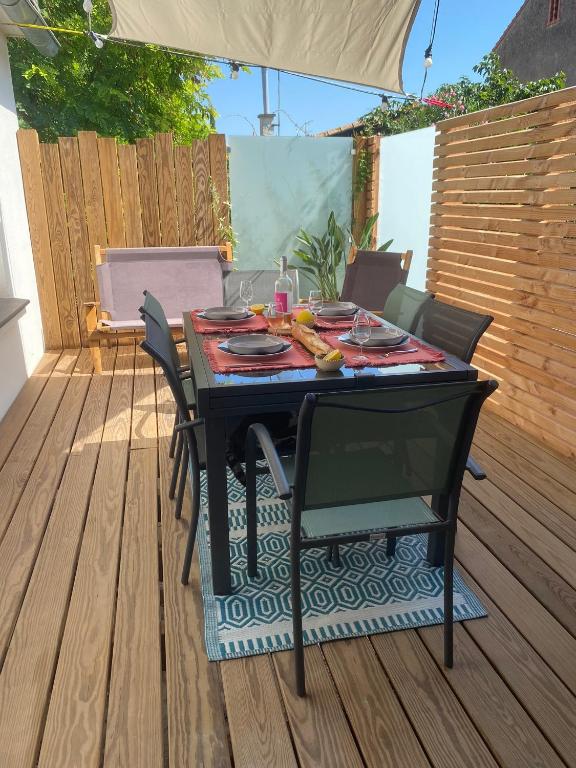 mesa y sillas en una terraza con mesa en La Maison de Jeanne en Narbona